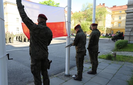wojskowi wieszający flagę Polski