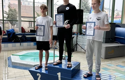 trzech uczniów stojących na podium