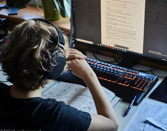 dziecko przed komputerem w słuchawkach