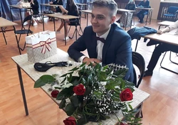 Na zdjęciu jeden z uczniów z kwiatami oraz prezentem 