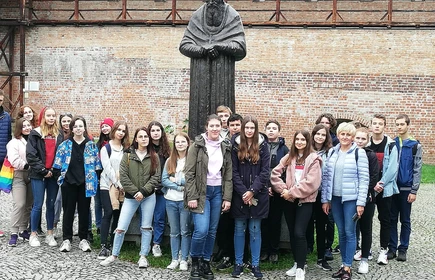 Grupowe zdjęcie uczniów przy pomniku 