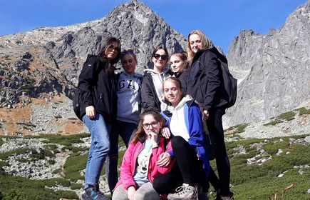 Grupowe zdjęcie pozujących dziewczyn w tle góry 