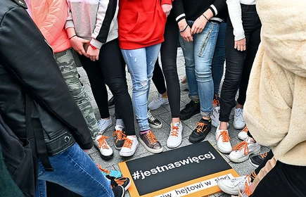 Uczniowie stojący w około plakaty #jestnaswięcej 