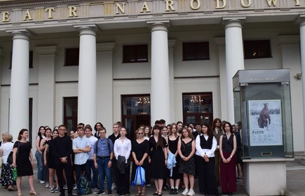 uczniowie stojący na tle budynku teatru