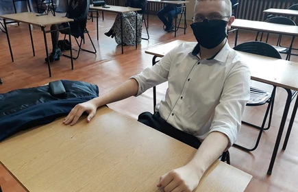 Na zdjęciu jeden z uczniów siedzący w ławce