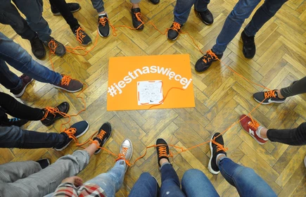 Na zdjęciu stopy uczestników oraz grafika #jestnaswięcej