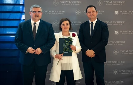 nauczyciel stojący ze starostą i wicestarostą