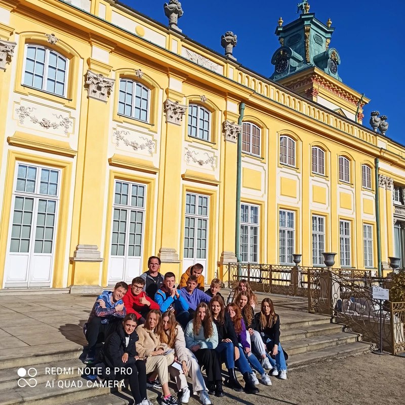 zdjęcie zbiorowe pod żółtym budynkiem