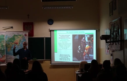 Na zdjęciu wykładowca podczas przemawiania oraz projektor