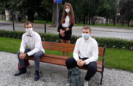Zdjęcie uczniów siedzących na ławce 