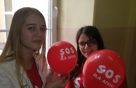 Na zdjęciu dwie uczennice z balonami SOS dla Afryki 