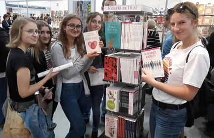 Grupowe zdjęcie uczniów trzymających książki 