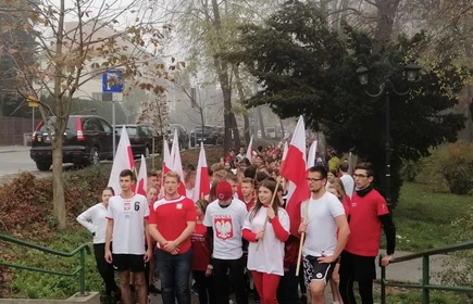 Uczestnicy biegu w barwach narodowych trzymających flagi 