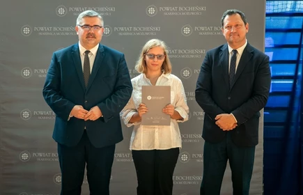 uczeń stojący ze starostą i wicestarostą