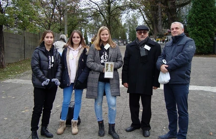 Grupa osób z puszkami podczas kwesty na cmentarzu 