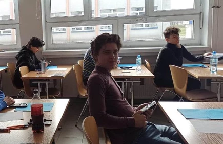 uczeń siedzący przy ławce w sali lekcyjnej