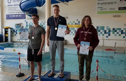 Na zdjęciu trzej uczniowie na podium wraz z dyplomami i medalami