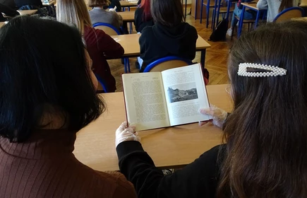 Na zdjęciu uczniowie przeglądający książkę 