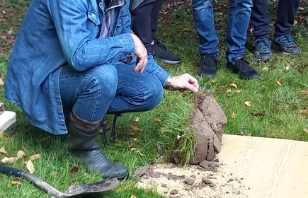 Na zdjęciu specjalista z kawałkiem wykopanej ziemi 