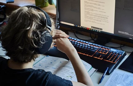 dziecko przed komputerem w słuchawkach