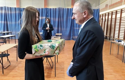 Uczennica wręczająca prezent nauczycielowi 