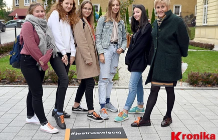 Osoby stojące przy plakacie #jestnaswięcej
