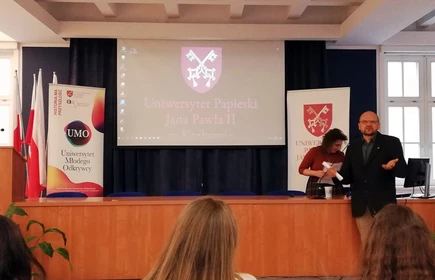 Zdjęcie prezentuję wykładowcę na tle ekranu projektora