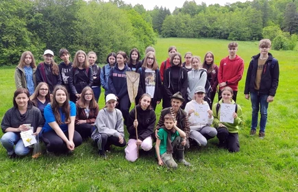 Grupowe zdjęcie uczni&oacute;w na łące 