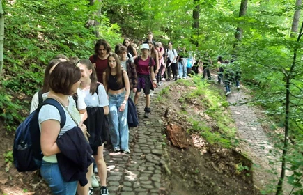 uczniowie idący szlakiem przez las