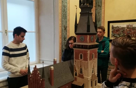 Grupa uczniów w muzeum przy makiecie kościoła