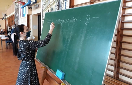 Zdjęcie osoby zapisującej na tablicy "Czas rozpoczęcia"