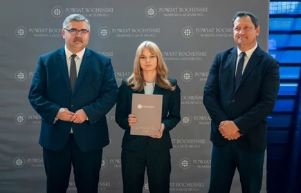 uczeń stojący ze starostą i wicestarostą