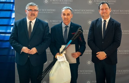 nauczyciel stojący ze starostą i wicestarostą