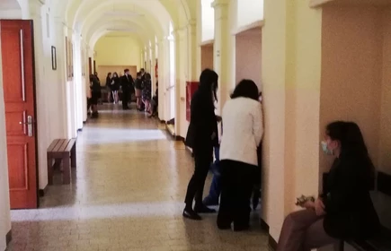 Zdjęcie maturzystów siedzących na korytarzu 