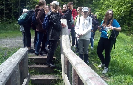 Zdjęcie uczni&oacute;w w trakcie wyprawy na drewnianych schodach 