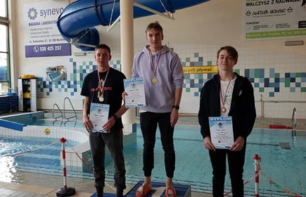 Na zdjęciu trzej uczniowie na podium wraz z dyplomami i medalami