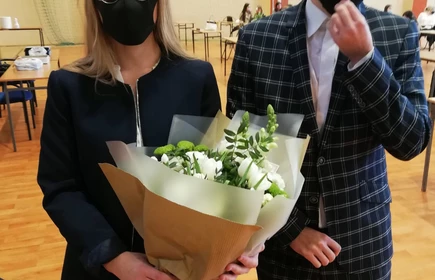 Na zdjęciu dwoje uczniów z kwiatami