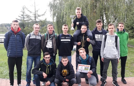 Grupowe zdjęcie uczniów trzymających puchar oraz dyplom 