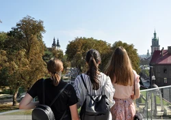 Zdjęcie prezentuje: uczestników projektu sfotografowanych od tyłu na tle Lwowa.