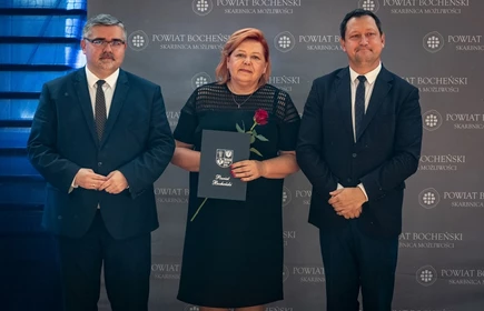nauczyciel stojący ze starostą i wicestarostą