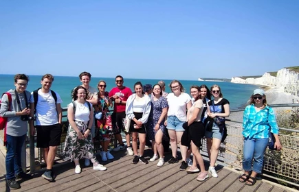 uczniowie stojący na tle morza