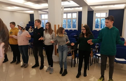 Na zdjęciu uczniowie trzymający się za ręce 