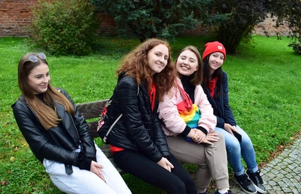 Grupowe zdjęcie uczniów siedzących na ławce