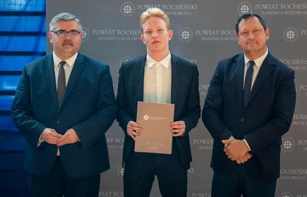 uczeń stojący ze starostą i wicestarostą