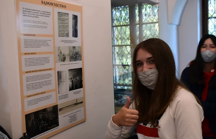 Uczennica przy tablicy muzealnej tablicy informacyjnej 