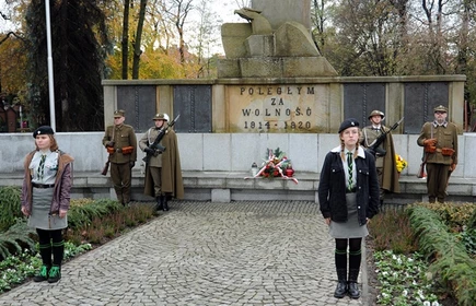 Na zdjęciu osoby biorące udział w obchodach na tle pomnika