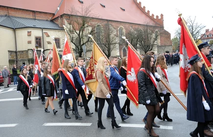 Na zdjęciu uczniowie trzymający sztandary