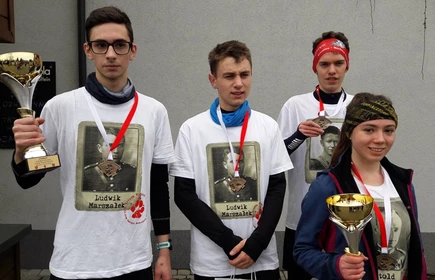 Grupowe zdjęcie zwycięzców z pucharami i medalami 