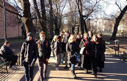 grupa uczniów idąca przez park