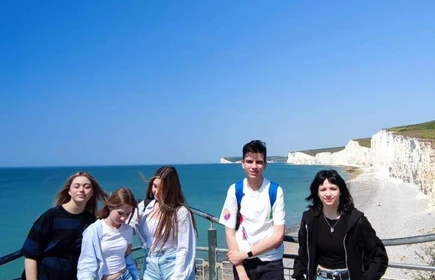 uczniowie stojący na tle morza